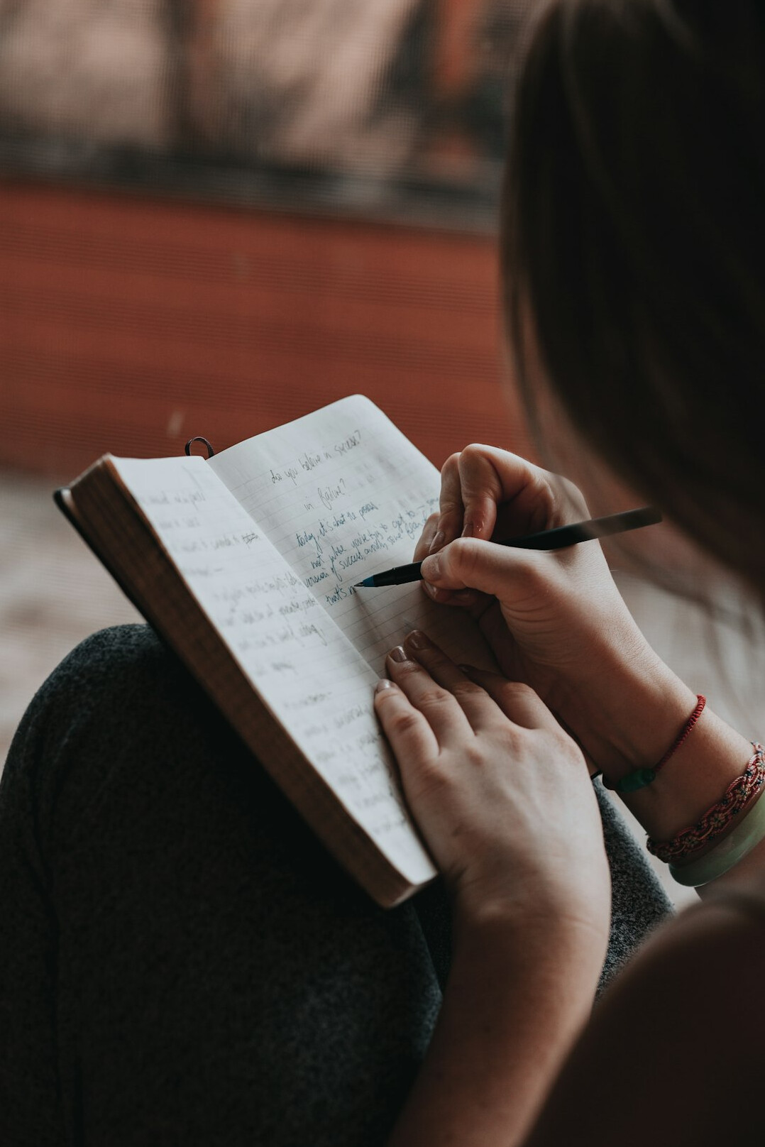 person writing goals in notebook